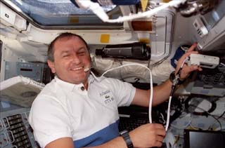 Mission specialist Vladimir Titov speaks through a microphone to the Mir crew while on the Atlantis's aft flight deck.